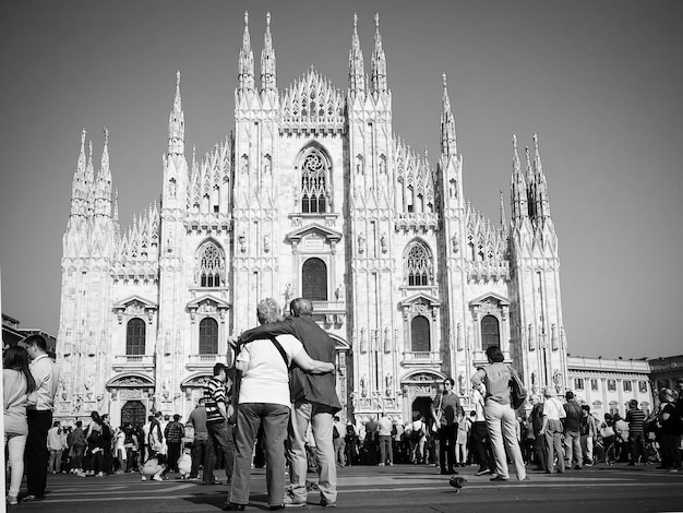 Turistas en la catedral de Milán contra el cielo