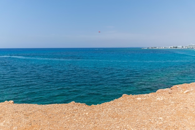 Turistas de CHIPRE AYIA NAPA se divertem em um pára-quedas sobre o mar Mediterrâneo perto do porto