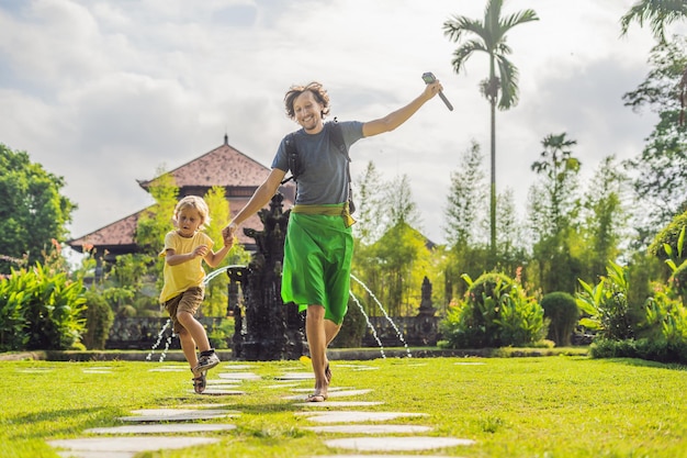 Turistas de pai e filho no templo hindu tradicional balinês Taman Ayun em Mengwi. Bali, Indonésia Viajando com o conceito de crianças