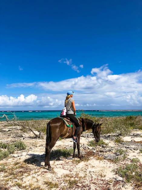 Turistas de passeios a cavalo em cuba. menina a cavalo na praia.