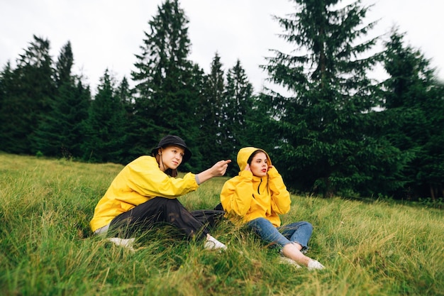 Turistas descansam em um prado nas montanhas em uma caminhada