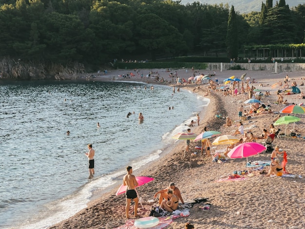 Los turistas descansan en una playa de arena junto al mar