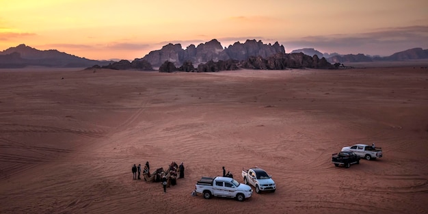 Turistas en el desierto de wadi rum al atardecer