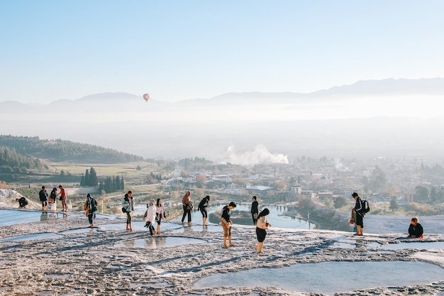 Los turistas disfrutan de las piscinas de agua termal caliente en el travertino de Pamukkale