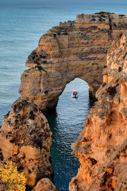 Foto turistas em um passeio de barco nas cavernas das formações do penhasco no algarve portugal férias de verão