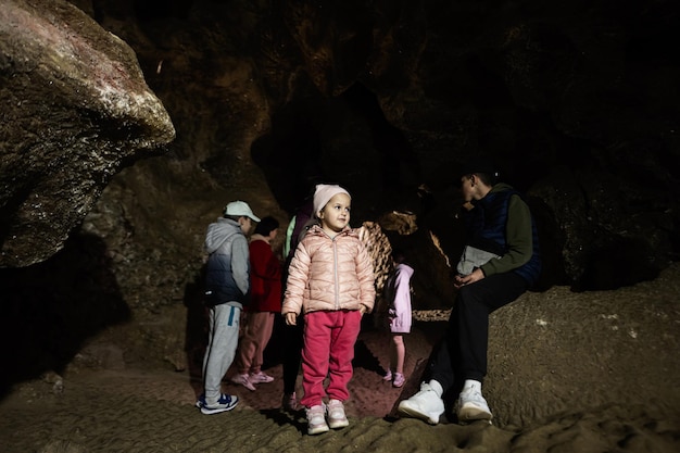 Turistas familiares caminhando na caverna e explorando-a