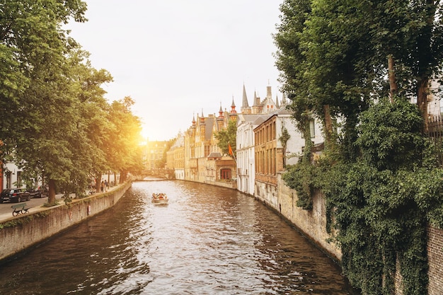 Turistas fazem um passeio panorâmico de barco para admirar as belas construções medievais ao longo dos canais de brugges bélgica