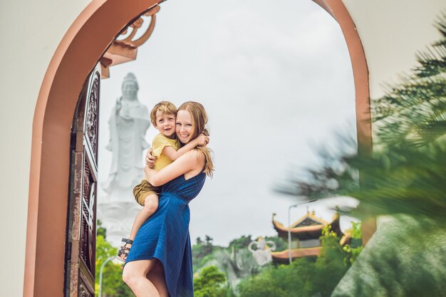 Turistas felices mamá e hijo en pagoda viajan al concepto de asia viajando con un concepto de bebé