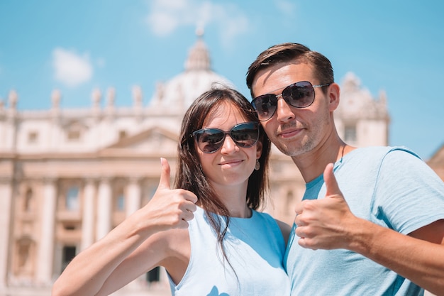 Turistas felices en Roma sobre la iglesia de la Basílica de San Pedro en la ciudad del Vaticano