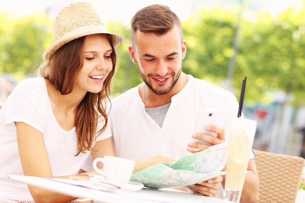 Turistas felizes com um mapa em um café