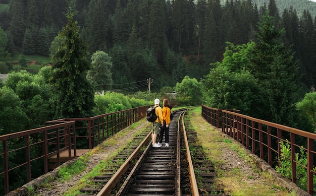 turistas fica na pista da ponte ferroviária nas montanhas dos Cárpatos Vorokhta