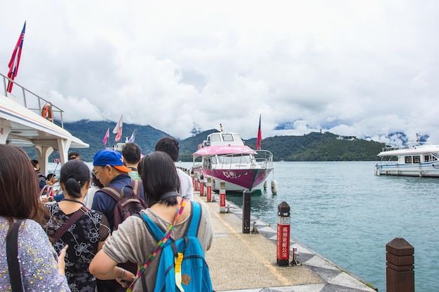 A los turistas les gusta visitar las hermosas atracciones alrededor del lago Sun Moon en un crucero en barco