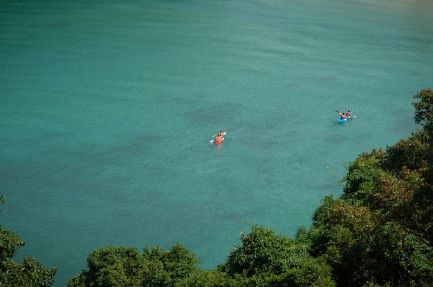 Los turistas hacen kayak en el mar ancho