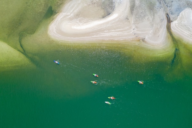 Los turistas de kayak en el mar verde vista superior aérea resumen concepto de fondo