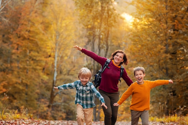 Turistas madre e hijos corriendo en el bosque