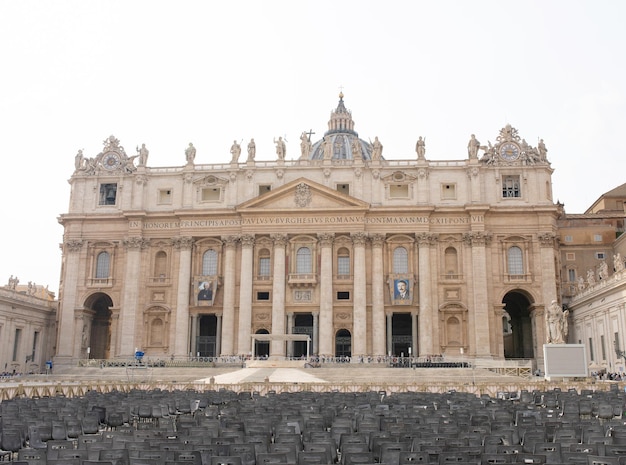 Turistas na praça de são pedro, obra-prima arquitetônica com a cúpula de michelangelo no vaticano.