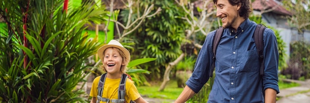 Los turistas de padre e hijo en bali caminan por las estrechas y acogedoras calles de ubud bali es un popular