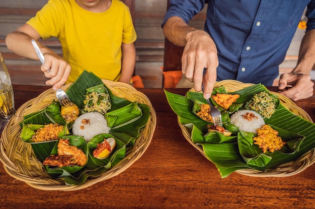 Turistas de papá e hijo en un café de comida indonesia Concepto de viajar con niños Qué hacer con los niños Lugar amigable para los niños