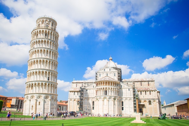 Foto turistas que visitan la torre inclinada de pisa, italia