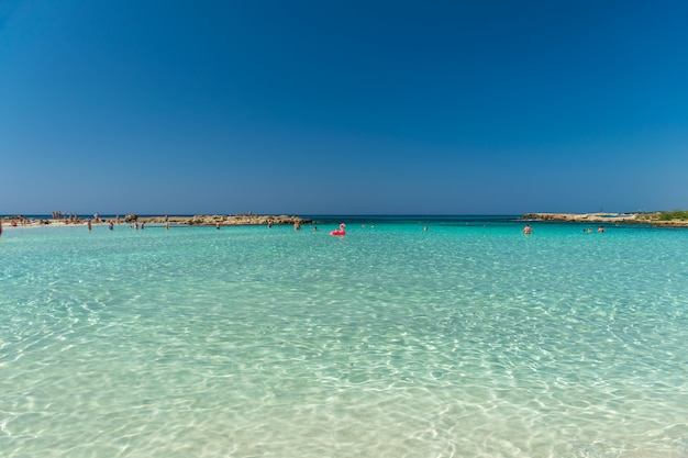 Los turistas se relajan y nadan en una de las playas más populares de la isla.