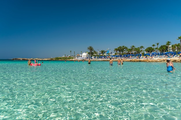 Los turistas se relajan y nadan en una de las playas más populares de la isla.