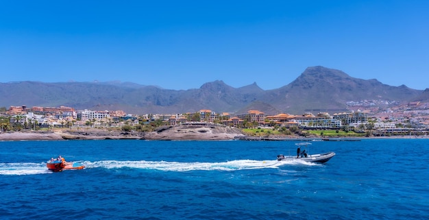 Turistas se divertindo em um barco na costa de adeje, no sul das ilhas canárias de tenerife