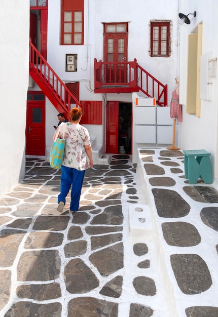 Turistas y tiendas entre las casas de arquitectura cíclada del casco antiguo Chora Mykonos Grecia