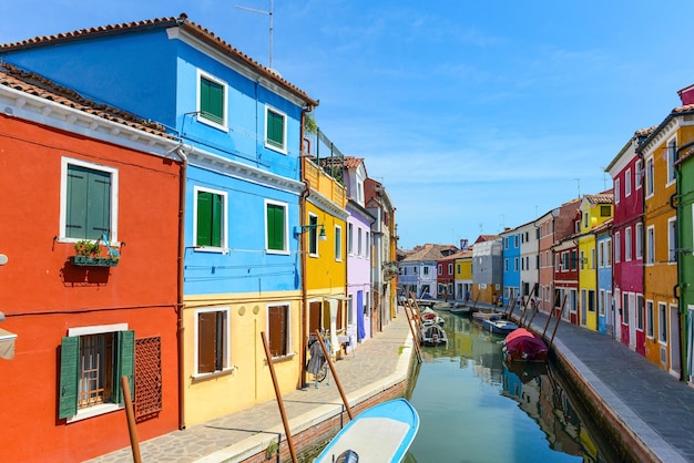 Turistas entre las tiendas y restaurantes soberanos en la calle principal de la isla de burano casas coloridas en el canal Venecia Italia