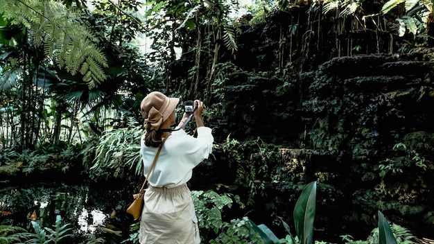 Turistas tomando fotografías de jardines ornamentales y cascadas.