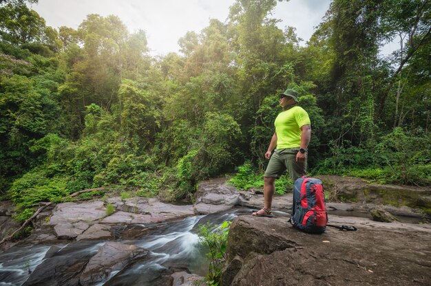 Turistas Viajeros con mochila para viajar Cascada en el Parque Nacional Khao Yai, Área de Patrimonio Mundial de la UNESCO de Tailandia. Trekking turístico a la cascada en el bosque tropical durante las vacaciones. Actividades vacacionales.