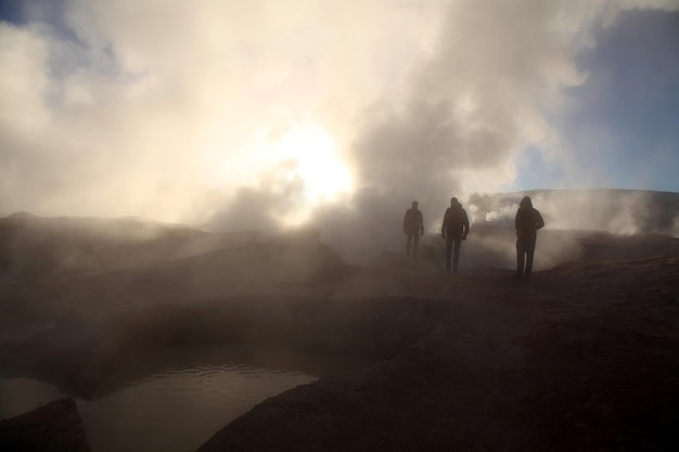 Turistas viendo el vapor que se eleva desde el géiser en el salar de uyuni
