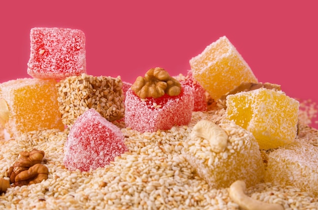 Turkish Delight Folie mit Nüssen und Sesam auf rosa Hintergrund Nahaufnahme Orientalische Süße