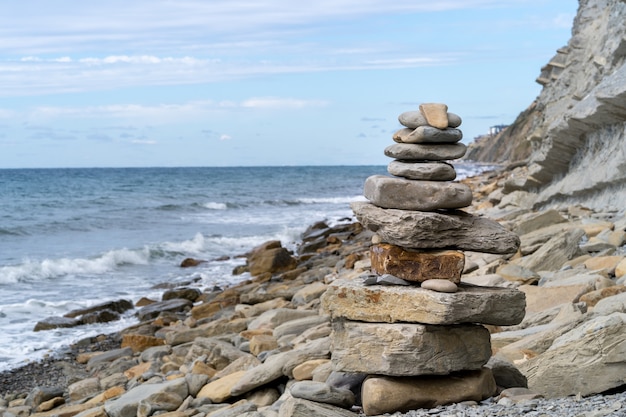 Turm von Kieseln gegen das Meer.