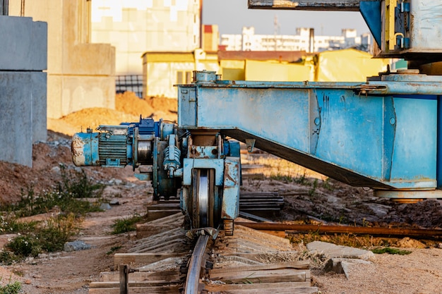 Turmdrehkran auf Schienen Nahaufnahme vor dem Hintergrund des bewölkten Himmels. Moderner Wohnungsbau. Wirtschaftsingenieurwesen. Bau von Hypothekenwohnungen.