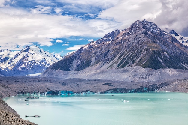 Turquesa bonita Lago Tasman Glacier e montanhas rochosas nas nuvens, Parque Nacional Mount Cook, Ilha Sul, Nova Zelândia