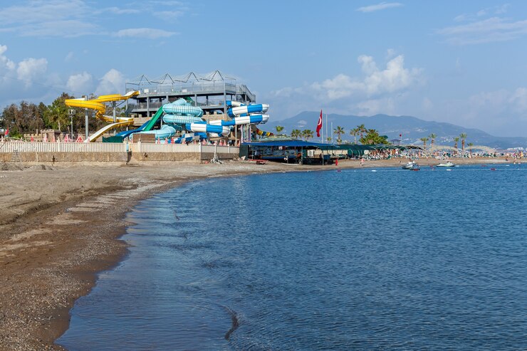 Foto turquia alanya, 5 de maio de 2019: um parque de diversões com diversos escorregadores coloridos e uma grande piscina em um dia ensolarado.