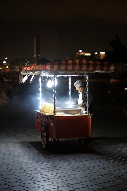 Turquía Estambul 09 25 2023 Un hombre está cocinando maíz para turistas en la calle durante la noche