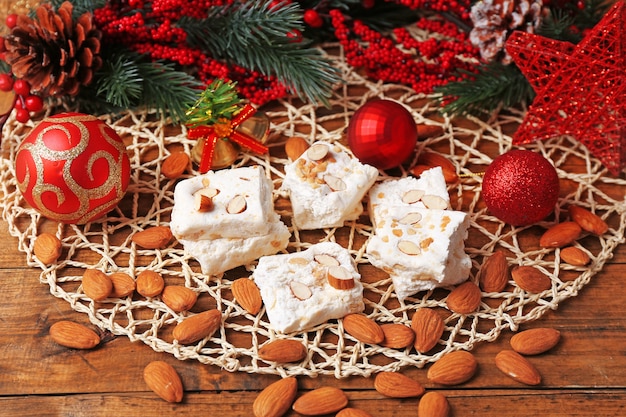 Turrón dulce con almendras y mesa de decoración navideña de cerca