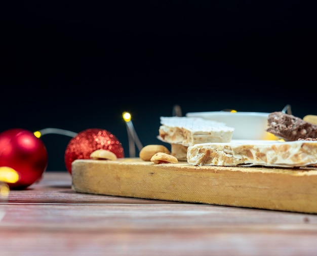 Turrón dulce de Navidad español tradicional con luces de Navidad en el fondo