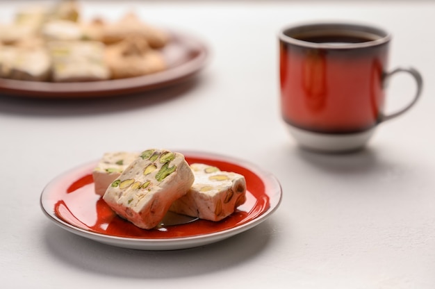 Turrón en un plato y una taza de té sobre un fondo claro. Enfoque selectivo.