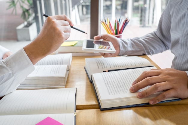 Tutor, aprendizaje, educación, grupo de adolescentes que aprenden estudiando una nueva lección de conocimiento en la biblioteca durante la enseñanza de la educación de amigos para prepararse para el examen, concepto de amistad juvenil en el campus juvenil