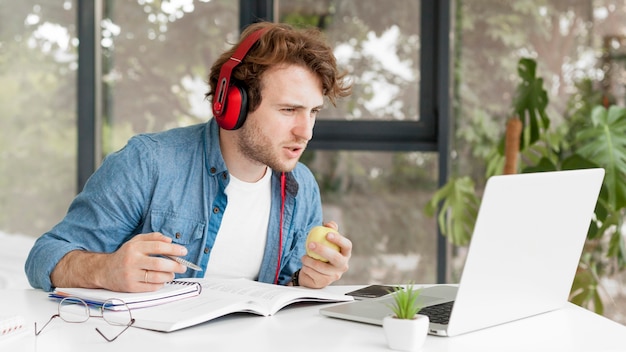 Tutor en casa sosteniendo una manzana