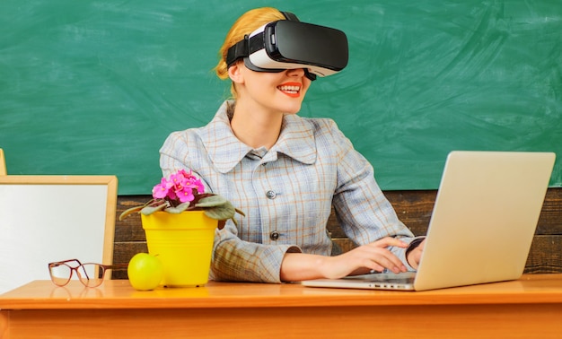 Tutor feliz em sala de aula. professor sorridente com laptop em fone de ouvido vr. educação digital. tecnologias modernas na escola inteligente.