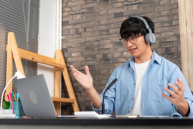 Tutor masculino usando auriculares, usando una computadora portátil y una cámara para enseñar una nueva lección por videoconferencia en la cámara web mientras explica ecuaciones matemáticas y fórmulas físicas en un curso de aprendizaje electrónico para estudiantes