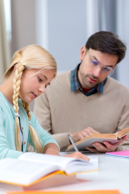 Tutor y niña en casa aprendiendo