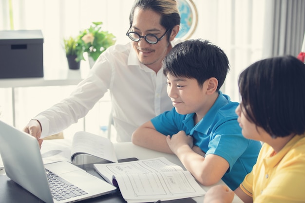 Tutor de niños en clase aprendiendo en computadora portátil