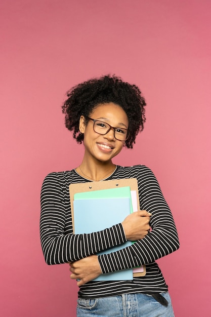 Tutor o maestra estadounidense mujer estudiante con gafas sosteniendo cuadernos y sonriendo