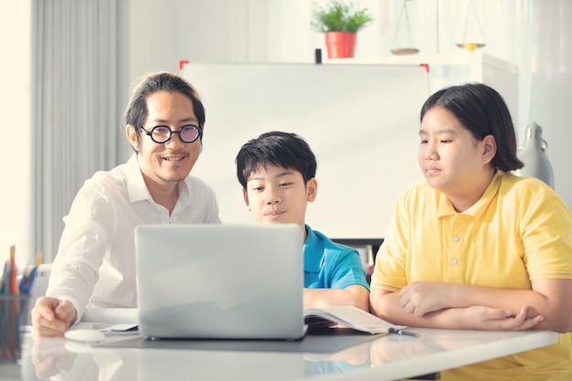 Tutorenkinder in der Klasse lernend auf Laptop-Computer