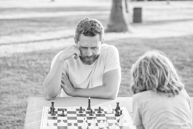 Tutoria pai e filho jogam jogo de lógica pai e filho jogando xadrez na mesa