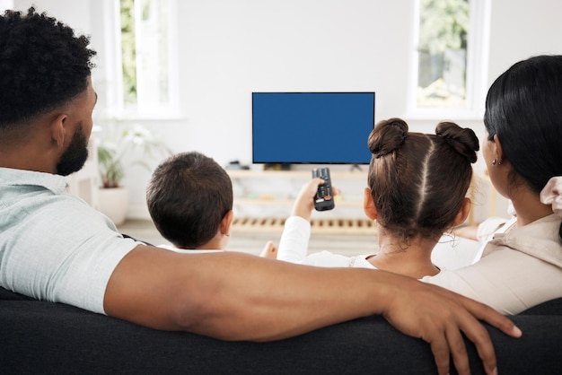 Foto tv de tela azul chroma key com uma família relaxada assistindo e desfrutando de streaming de séries de filmes e espaço de cópia de entretenimento visão traseira de pais e filhos passando tempo de lazer assistindo televisão